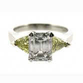 Platinum ring set with emerald cut diamond and 2 natural fancy yellow trillian cut diamonds